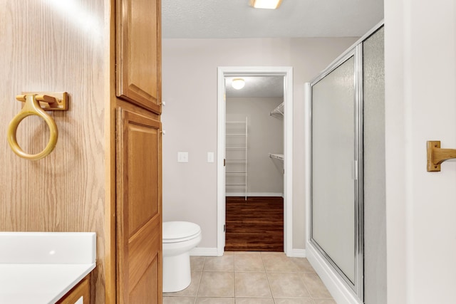 315 Rock Ridge Rd, Branson West, MO 65737 - bathroom with a shower stall, tile patterned flooring, toilet, and a spacious closet