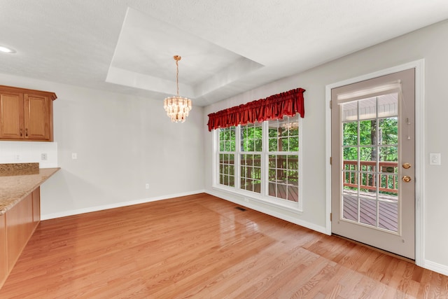 315 Rock Ridge Rd, Branson West, MO 65737 - unfurnished dining area with light wood-style floors, a chandelier, baseboards, and a raised ceiling