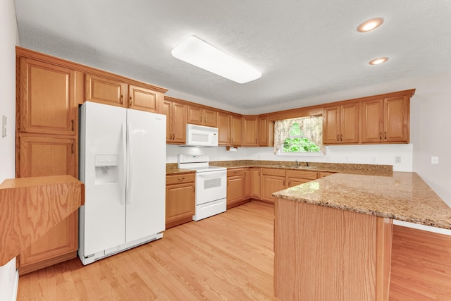 315 Rock Ridge Rd, Branson West, MO 65737 - kitchen featuring white appliances, a peninsula, light wood-style floors, a sink, and light stone counters