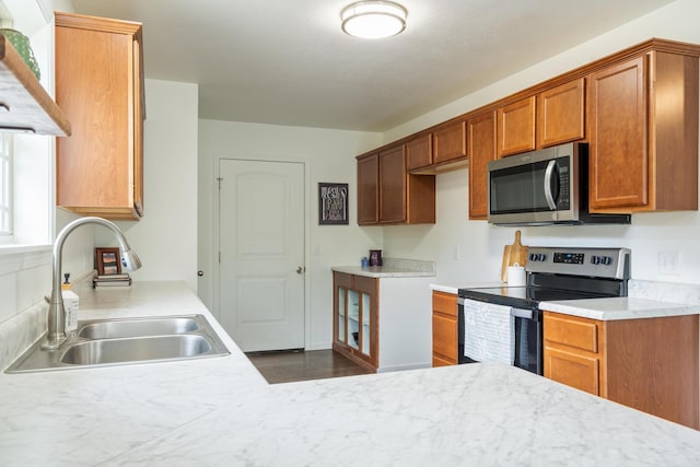 343 Cedar Glade Dr, Branson West, MO 65737 - kitchen featuring stainless steel appliances, a sink, light countertops, brown cabinets, and dark wood-type flooring