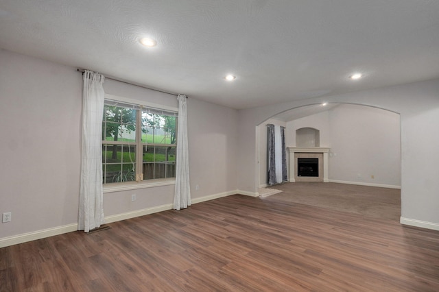 2304 S 12th St, Ozark, MO 65721 - unfurnished living room with arched walkways, wood finished floors, baseboards, recessed lighting, and a fireplace