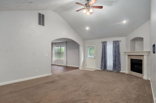2304 S 12th St, Ozark, MO 65721 - unfurnished living room featuring ceiling fan, arched walkways, vaulted ceiling, carpet flooring, and a tile fireplace