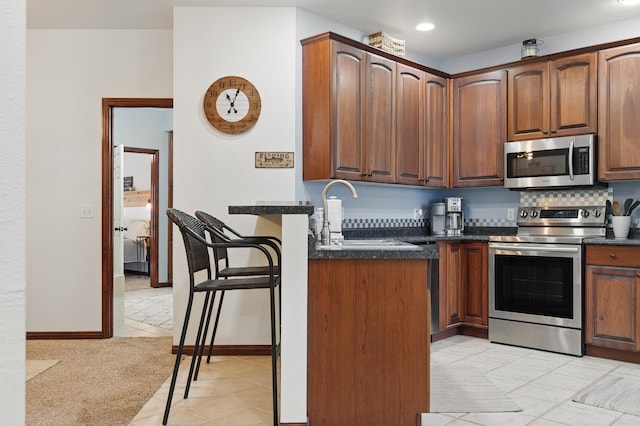 235 Lower Emerald Bay Cir Unit C-6, Hollister, MO 65672 - kitchen with stainless steel appliances, a sink, light tile patterned floors, recessed lighting, and baseboards