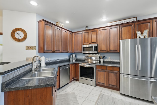 235 Lower Emerald Bay Cir Unit C-6, Hollister, MO 65672 - kitchen with appliances with stainless steel finishes, a sink, dark countertops, light tile patterned floors, and a peninsula
