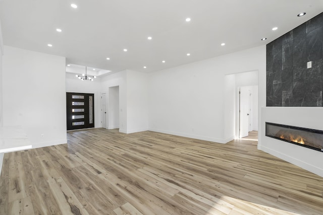 2048 N Sun Valley Dr, Springfield, MO 65802 - unfurnished living room with light wood-style floors, recessed lighting, a fireplace, baseboards, and a chandelier