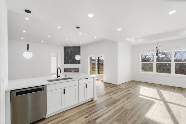 2048 N Sun Valley Dr, Springfield, MO 65802 - kitchen featuring stainless steel dishwasher, a sink, open floor plan, light stone counters, and healthy amount of natural light