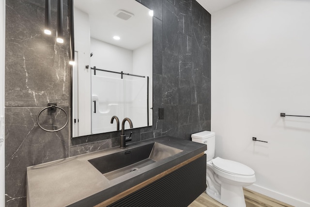 2048 N Sun Valley Dr, Springfield, MO 65802 - bathroom featuring wood finished floors, decorative backsplash, vanity, toilet, and tile walls
