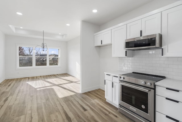 2048 N Sun Valley Dr, Springfield, MO 65802 - kitchen with stainless steel appliances, baseboards, a chandelier, light countertops, and decorative backsplash