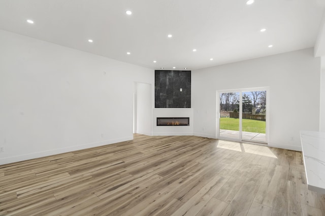 2048 N Sun Valley Dr, Springfield, MO 65802 - unfurnished living room with recessed lighting, light wood-style flooring, a large fireplace, and baseboards