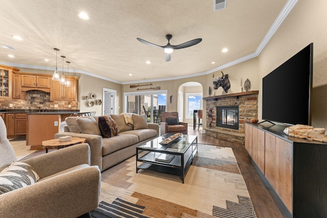 130 Royal Vista Dr Unit 601, Branson, MO 65616 - living room with wood finished floors, crown molding, arched walkways, recessed lighting, and a fireplace