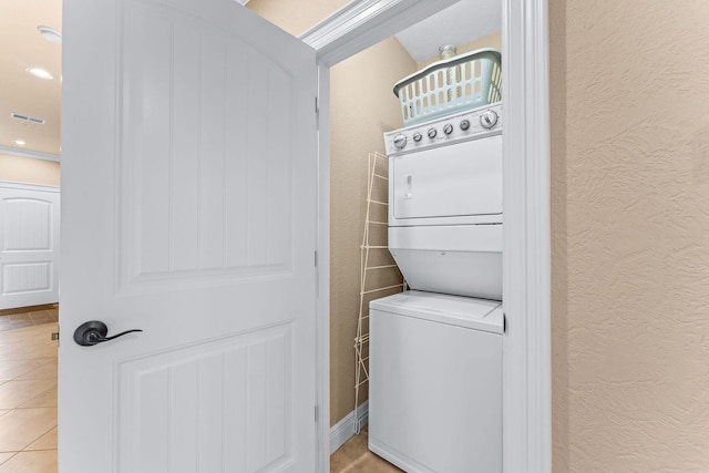 130 Royal Vista Dr Unit 601, Branson, MO 65616 - washroom with stacked washer and clothes dryer, a textured wall, and light tile patterned flooring