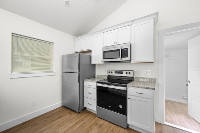 1211 S Pennsylvania Ave, Springfield, MO 65807 - kitchen with stainless steel appliances, lofted ceiling, white cabinets, light wood finished floors, and baseboards