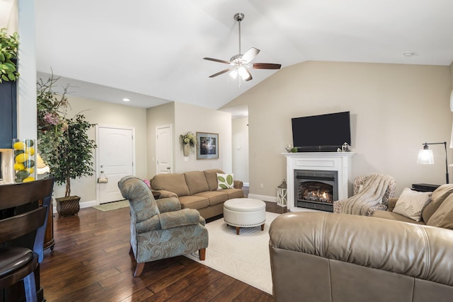 94 W Pine Ln, Reeds Spring, MO 65737 - living room with a ceiling fan, dark wood-style flooring, vaulted ceiling, baseboards, and a warm lit fireplace