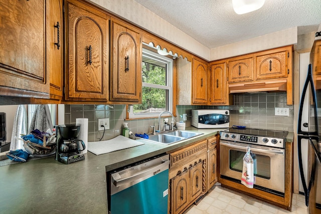2711 E Stanford St, Springfield, MO 65804 - kitchen with stainless steel appliances, under cabinet range hood, brown cabinets, a sink, and a textured ceiling