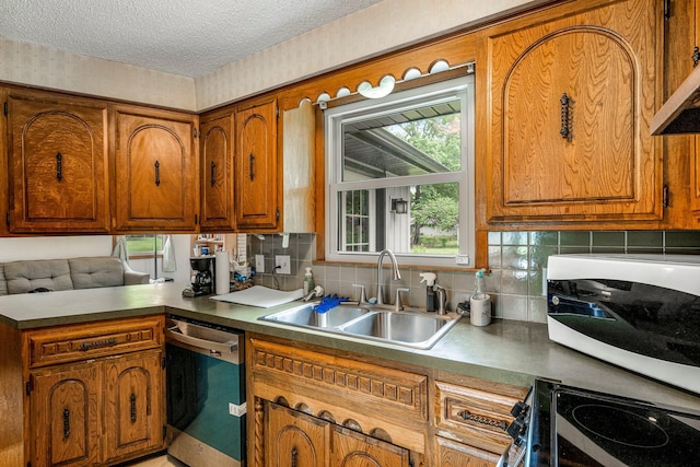 2711 E Stanford St, Springfield, MO 65804 - kitchen with dishwashing machine, white microwave, a sink, brown cabinetry, and a textured ceiling