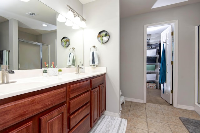 326 Country Bluff Dr, Branson, MO 65616 - full bathroom featuring a stall shower, double vanity, tile patterned flooring, a walk in closet, and toilet