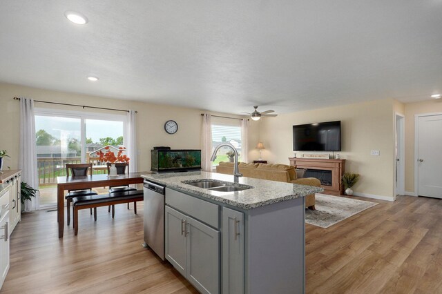 1132 E Lakota St, Nixa, MO 65714 - kitchen with a sink, stainless steel dishwasher, open floor plan, a glass covered fireplace, and an island with sink