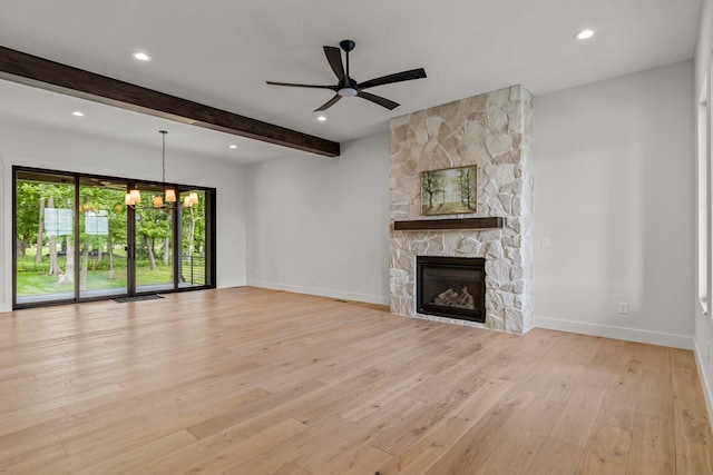 5567 E Wild Horse Dr, Springfield, MO 65802 - unfurnished living room featuring light wood-style flooring, beamed ceiling, baseboards, a stone fireplace, and a ceiling fan