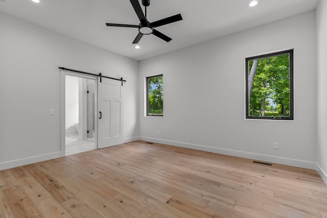 5567 E Wild Horse Dr, Springfield, MO 65802 - unfurnished bedroom featuring baseboards, recessed lighting, a barn door, and light wood-style flooring