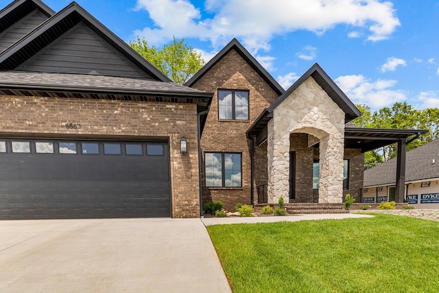 5567 E Wild Horse Dr, Springfield, MO 65802 - view of front of home with driveway, a front lawn, brick siding, an attached garage, and stone siding