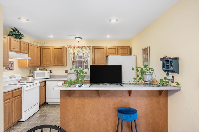 120 Deer Run Rd, Branson, MO 65616 - kitchen with white appliances, under cabinet range hood, a breakfast bar, light countertops, and a peninsula