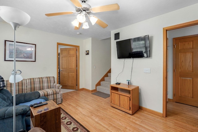 5473 N State Highway 125, Strafford, MO 65757 - living room featuring light wood-style floors, stairs, a ceiling fan, and baseboards