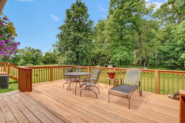 5473 N State Highway 125, Strafford, MO 65757 - wooden deck with outdoor dining space, central AC, view of scattered trees, and a yard