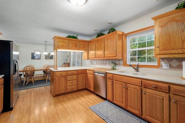 5473 N State Highway 125, Strafford, MO 65757 - kitchen featuring appliances with stainless steel finishes, a sink, light countertops, a peninsula, and light wood-type flooring