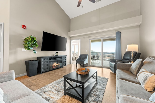 200 Majestic Dr # 423, Branson, MO 65616 - living area with high vaulted ceiling, a glass covered fireplace, ceiling fan, light wood-type flooring, and baseboards