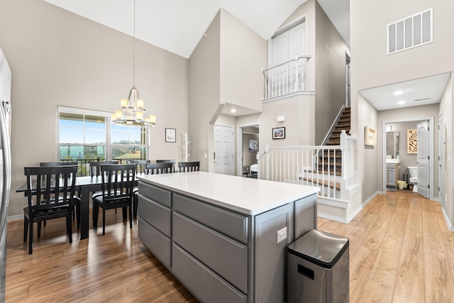 200 Majestic Dr # 423, Branson, MO 65616 - kitchen with gray cabinetry, high vaulted ceiling, a chandelier, light wood finished floors, and a center island