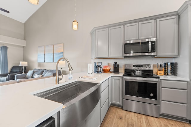 200 Majestic Dr # 423, Branson, MO 65616 - kitchen featuring stainless steel appliances, gray cabinets, a sink, open floor plan, and high vaulted ceiling