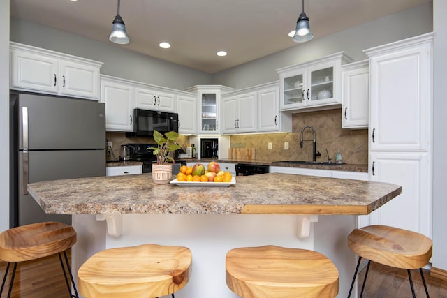 5052 E Cherry Pl, Springfield, MO 65809 - kitchen with black appliances, a sink, hanging light fixtures, wood finished floors, and recessed lighting