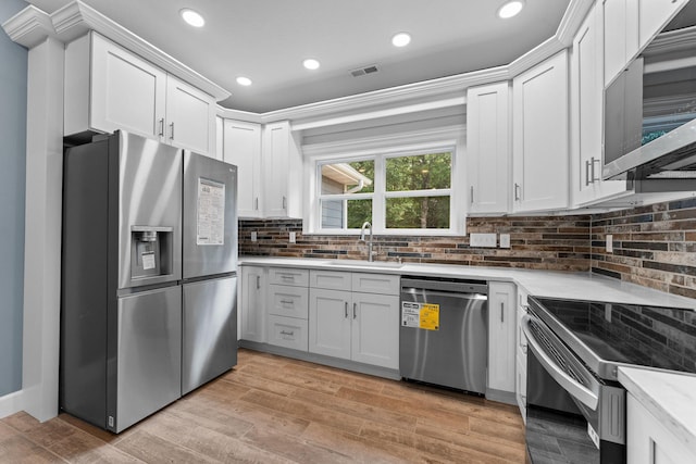 680 Highpoints Rdg, Branson, MO 65616 - kitchen with stainless steel appliances, light countertops, a sink, backsplash, and white cabinets
