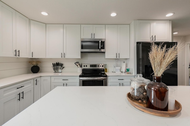 777 S Elm St, Marshfield, MO 65706 - kitchen featuring appliances with stainless steel finishes, white cabinetry, recessed lighting, and light stone countertops