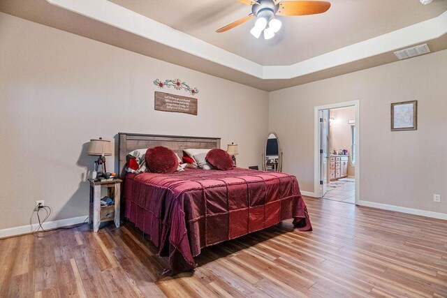 6 Glory Ln, Blue Eye, MO 65611 - bedroom with light wood-style flooring, baseboards, a raised ceiling, ensuite bath, and a ceiling fan