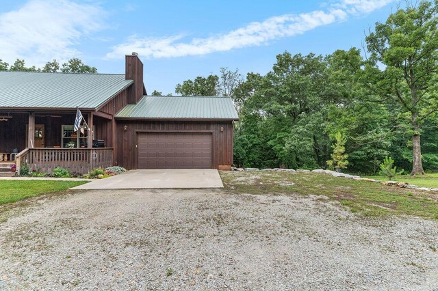 6 Glory Ln, Blue Eye, MO 65611 - view of home's exterior featuring covered porch, a chimney, metal roof, and a garage