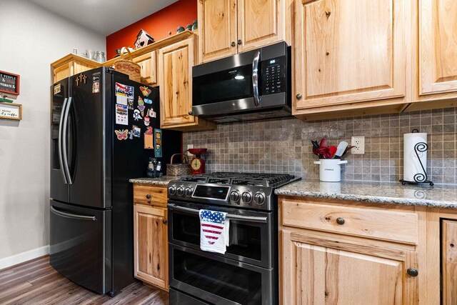 6 Glory Ln, Blue Eye, MO 65611 - kitchen with range with two ovens, black refrigerator with ice dispenser, tasteful backsplash, baseboards, and wood finished floors