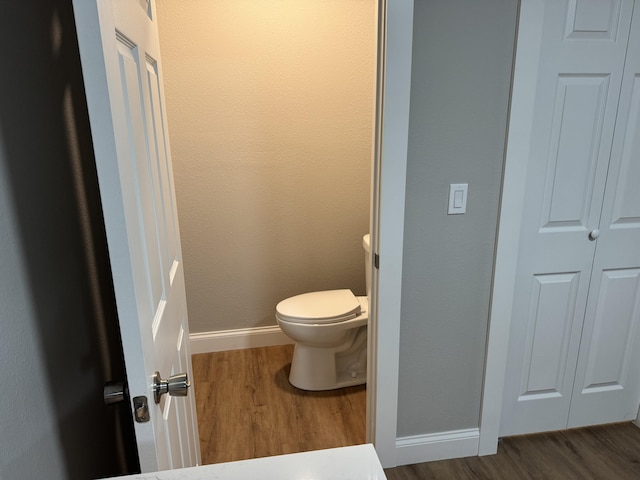 1922 S Village Ln, Bolivar, MO 65613 - bathroom featuring wood finished floors, baseboards, toilet, and a closet
