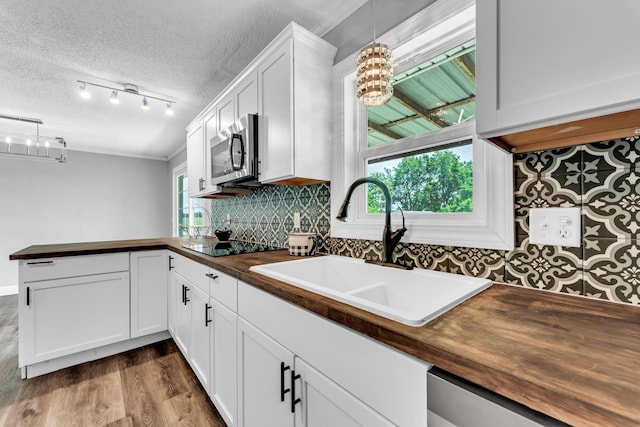 32 State Road F, Buffalo, MO 65622 - kitchen with wooden counters, a chandelier, appliances with stainless steel finishes, a sink, and a textured ceiling