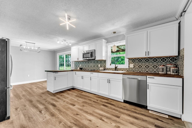 32 State Road F, Buffalo, MO 65622 - kitchen featuring stainless steel appliances, a sink, a peninsula, white cabinets, and a textured ceiling