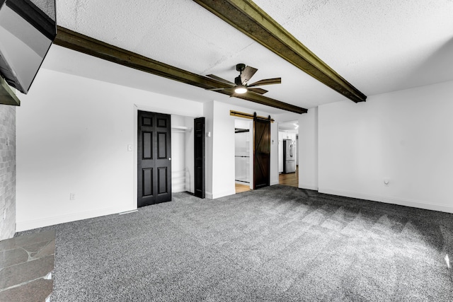 32 State Road F, Buffalo, MO 65622 - carpeted spare room with a barn door, beam ceiling, a ceiling fan, a textured ceiling, and baseboards