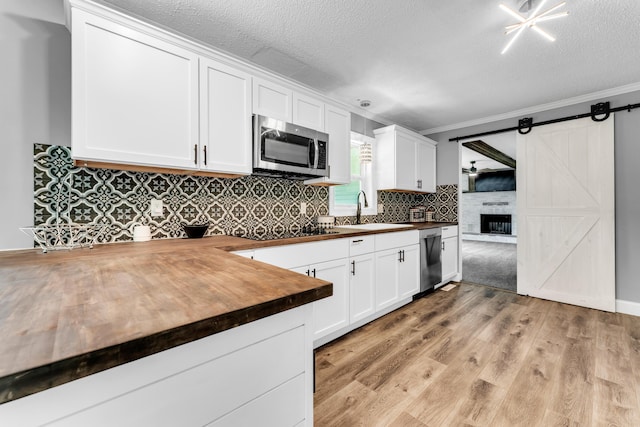 32 State Road F, Buffalo, MO 65622 - kitchen with stainless steel appliances, wooden counters, a sink, ornamental molding, and decorative backsplash