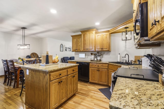 1427 W Missouri St, Buffalo, MO 65622 - kitchen with black dishwasher, a sink, light wood-type flooring, a breakfast bar, and a center island
