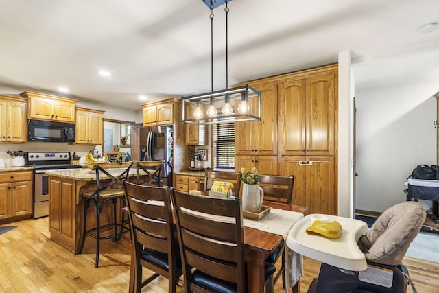 1427 W Missouri St, Buffalo, MO 65622 - kitchen featuring stainless steel appliances, light wood-style floors, a breakfast bar, a center island, and light stone counters