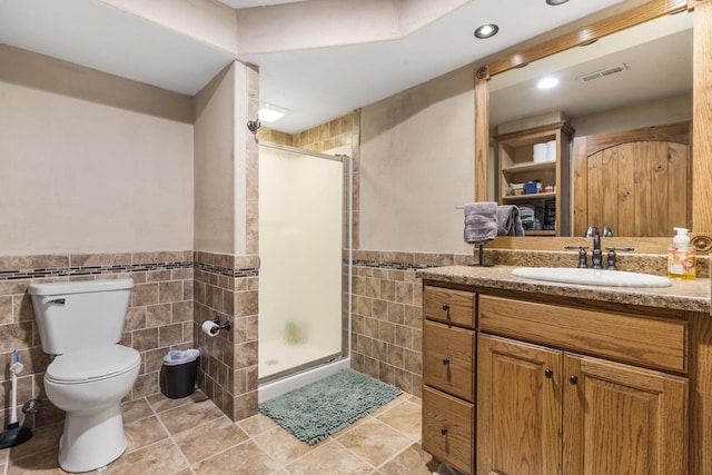 1427 W Missouri St, Buffalo, MO 65622 - bathroom featuring tile walls, vanity, toilet, a shower stall, and wainscoting
