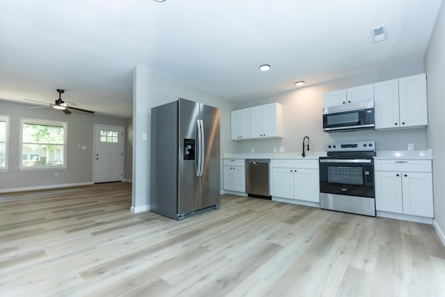 3218 W Countryside Dr, Springfield, MO 65807 - kitchen with appliances with stainless steel finishes, light wood-style floors, light countertops, white cabinets, and baseboards