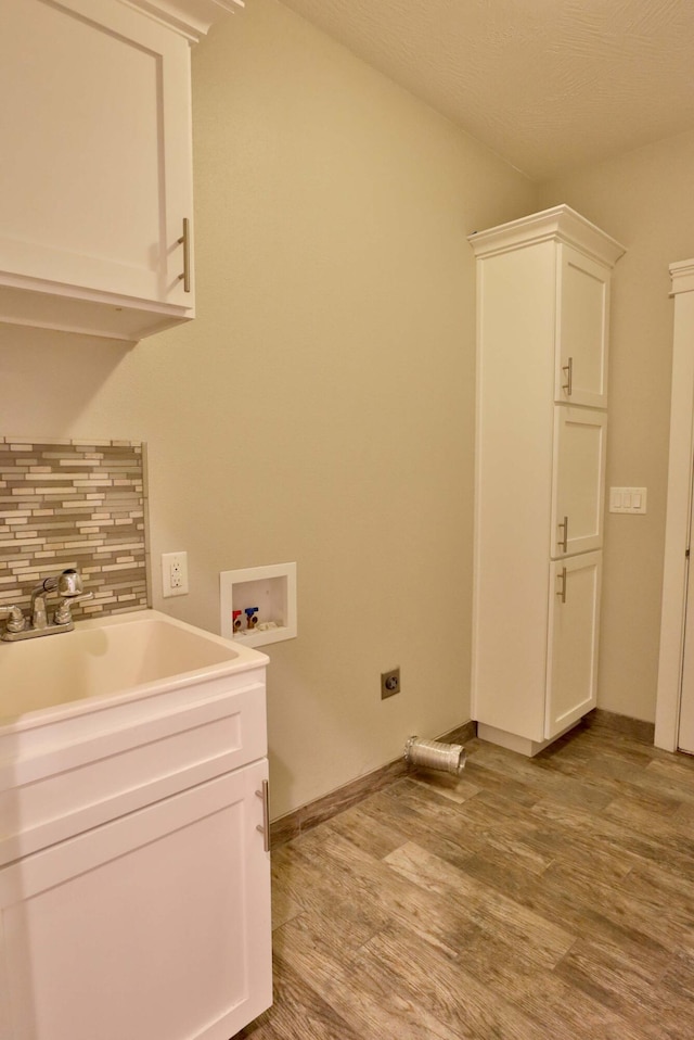 1189 N Cedar Ridge Ave, Springfield, MO 65802 - laundry area with electric dryer hookup, light wood-style flooring, washer hookup, cabinet space, and baseboards