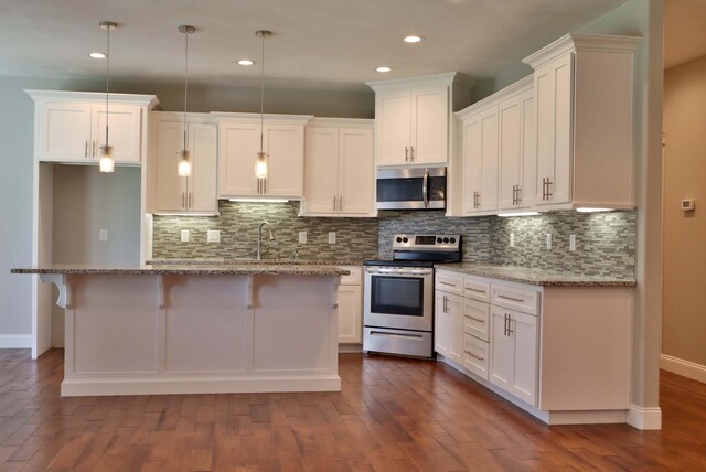 1189 N Cedar Ridge Ave, Springfield, MO 65802 - kitchen with appliances with stainless steel finishes, baseboards, white cabinets, a kitchen island, and recessed lighting