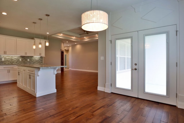 1189 N Cedar Ridge Ave, Springfield, MO 65802 - kitchen with dark wood-style floors, decorative backsplash, baseboards, white cabinetry, and a kitchen bar