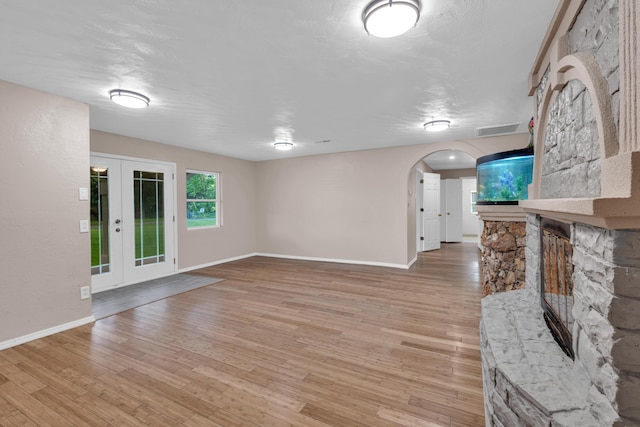 875-883 State Route T, West Plains, MO 65775 - unfurnished living room with arched walkways, light wood-type flooring, baseboards, and french doors